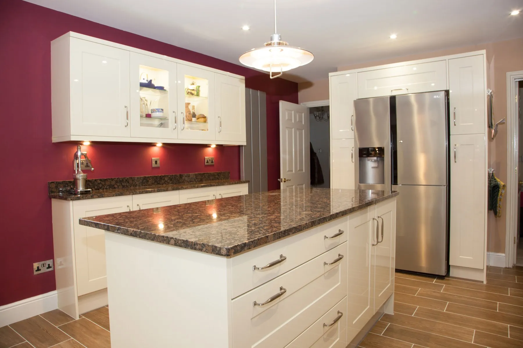 Island and American fridge freezer against a burgundy wall